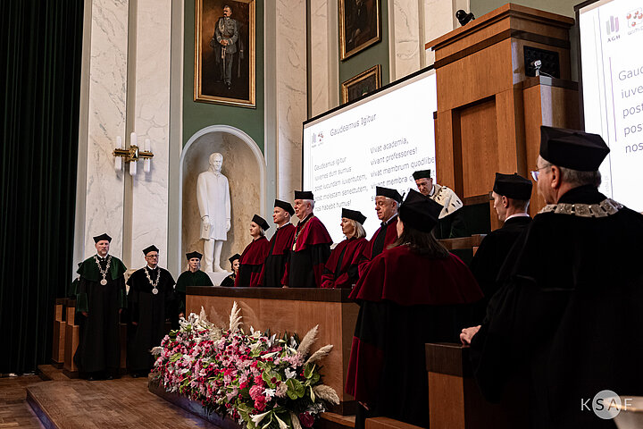Zdjęcie grupy władz akademickich w galowych togach w trakcie uroczystości.